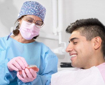 Dentist showing patient how to put on clear aligner