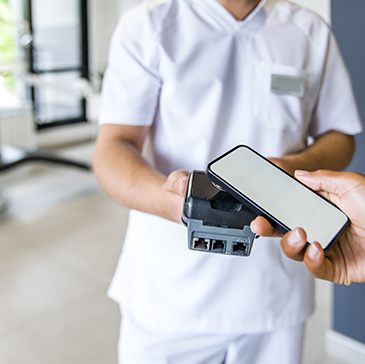 A woman paying for dental crowns by using her smartphone