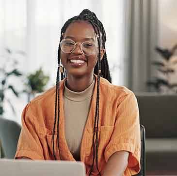 Woman smiling while working on laptop at home