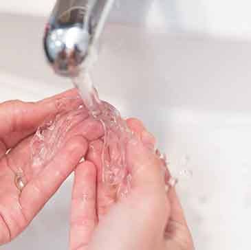 Patient rinsing aligners in sink